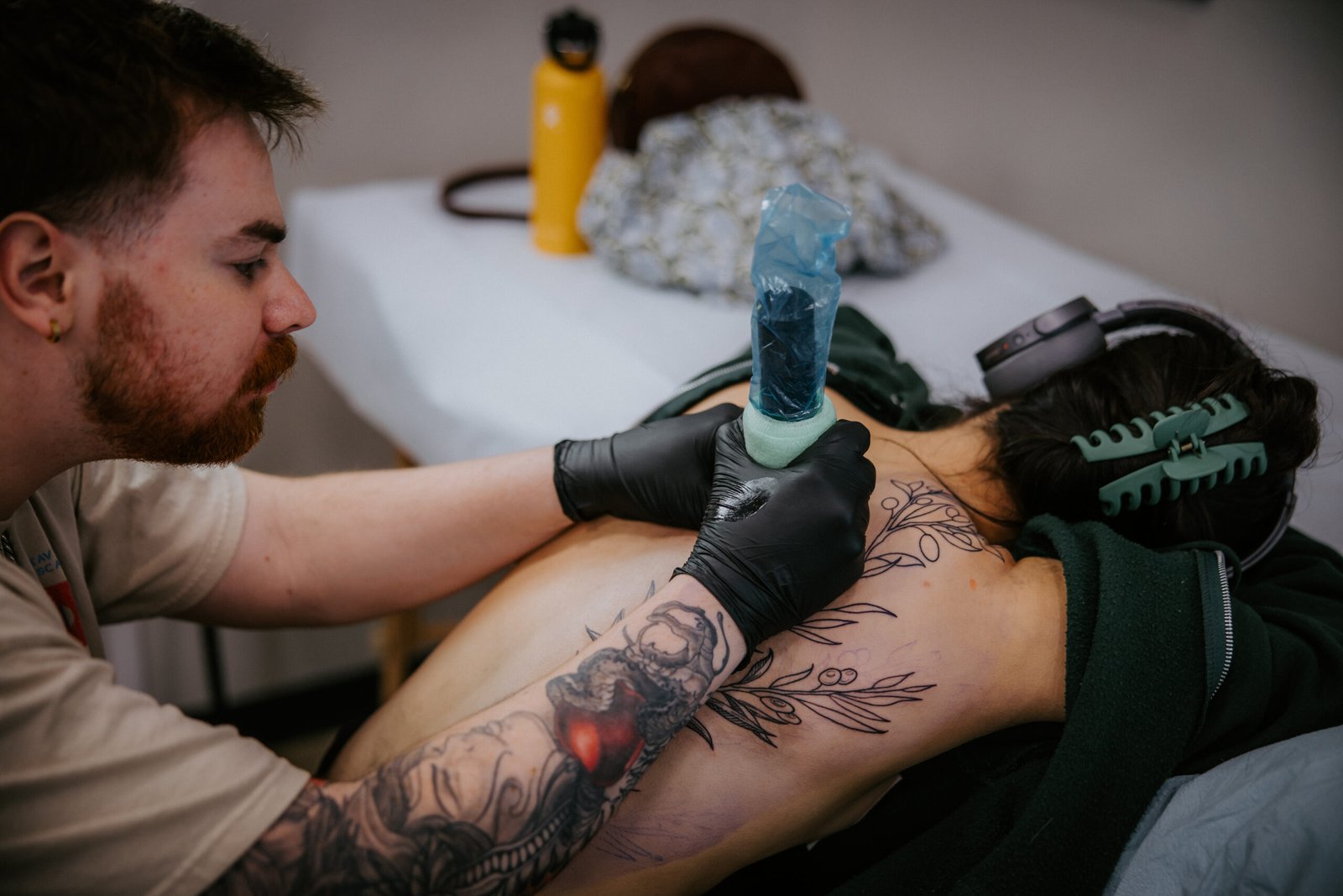 Tattoo Artist Payton working on comfortable client large back tattoo